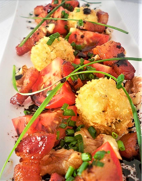 Handcrafted tomato dish with chives and golden croquettes