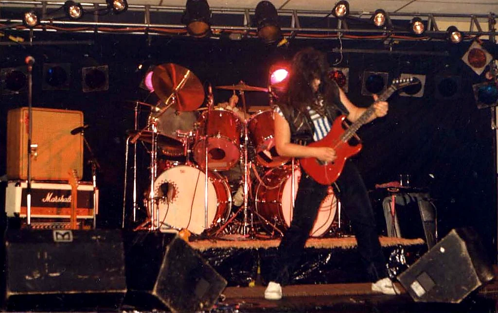 Benny Doro playing guitar onstage with Unchained.