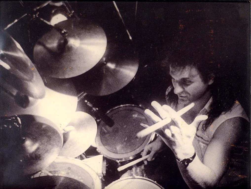 Tony Melitza photographed over his drum kit.