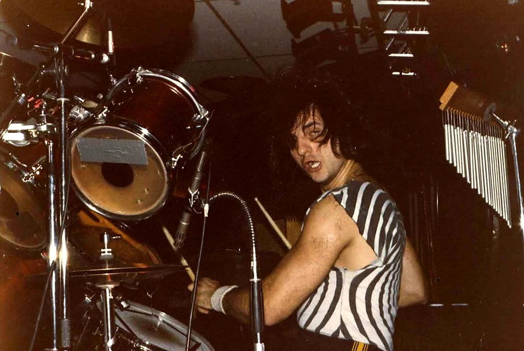 Tony Melitza smiling from behind the drums.