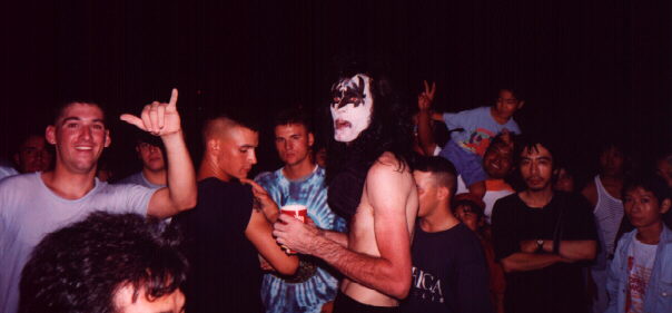 A band member in makeup among the crowd.