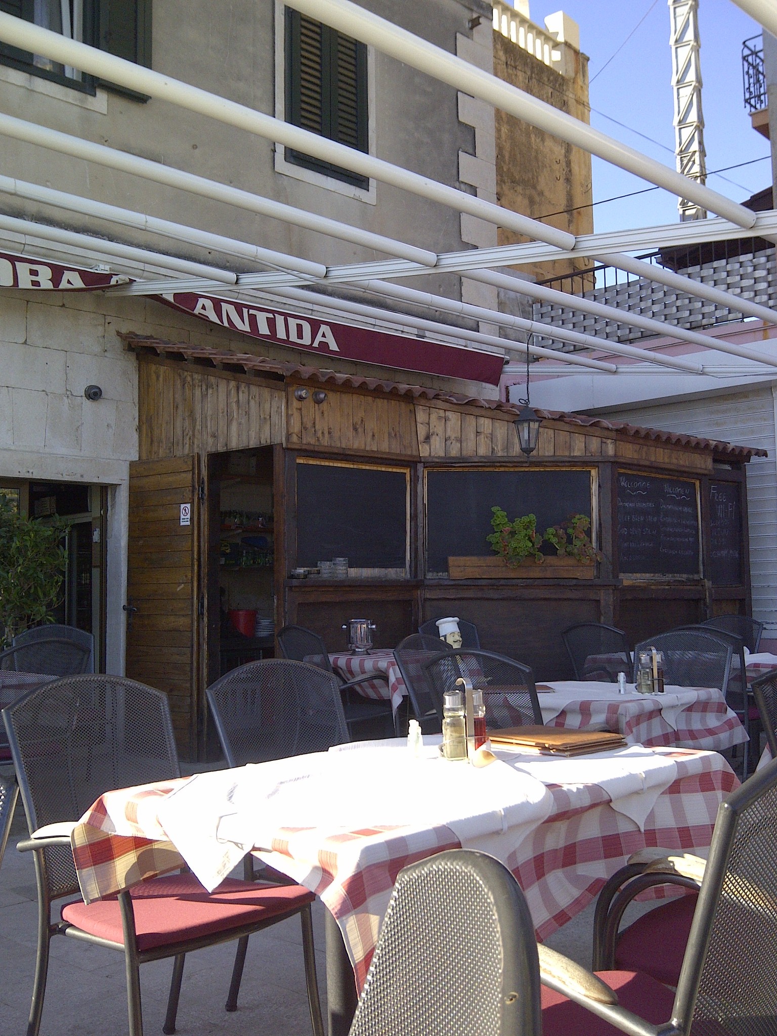 An outdoor restaurant terrace with checked tablecloths