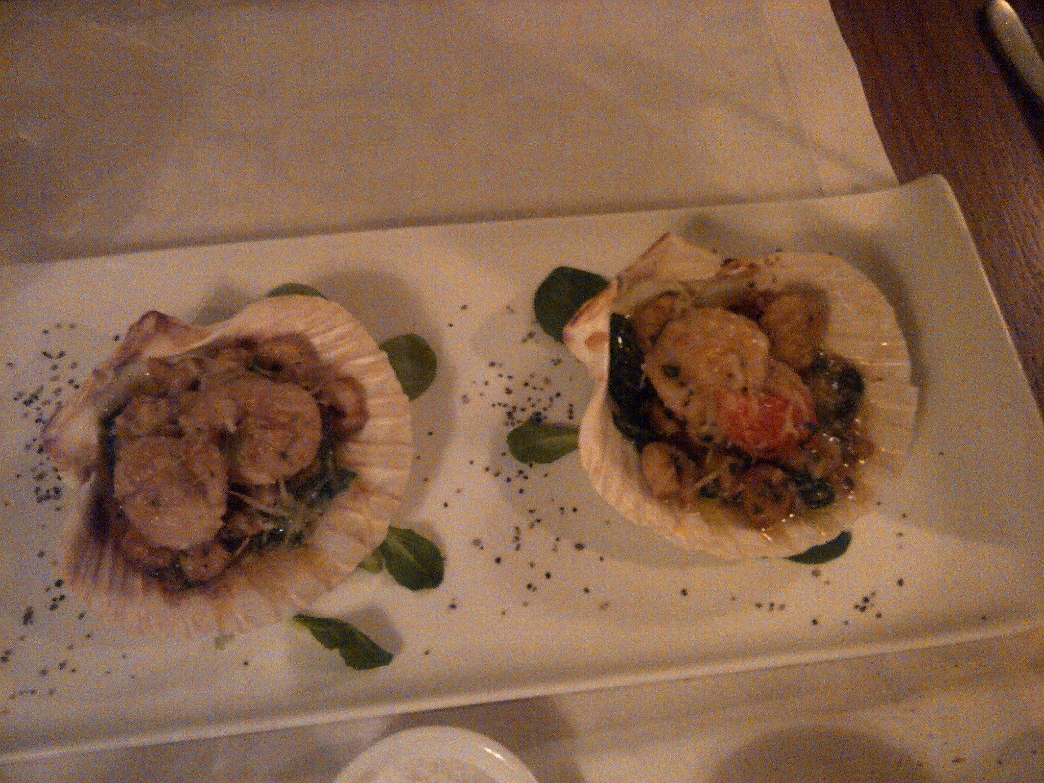 Two carefully plated seafood dishes