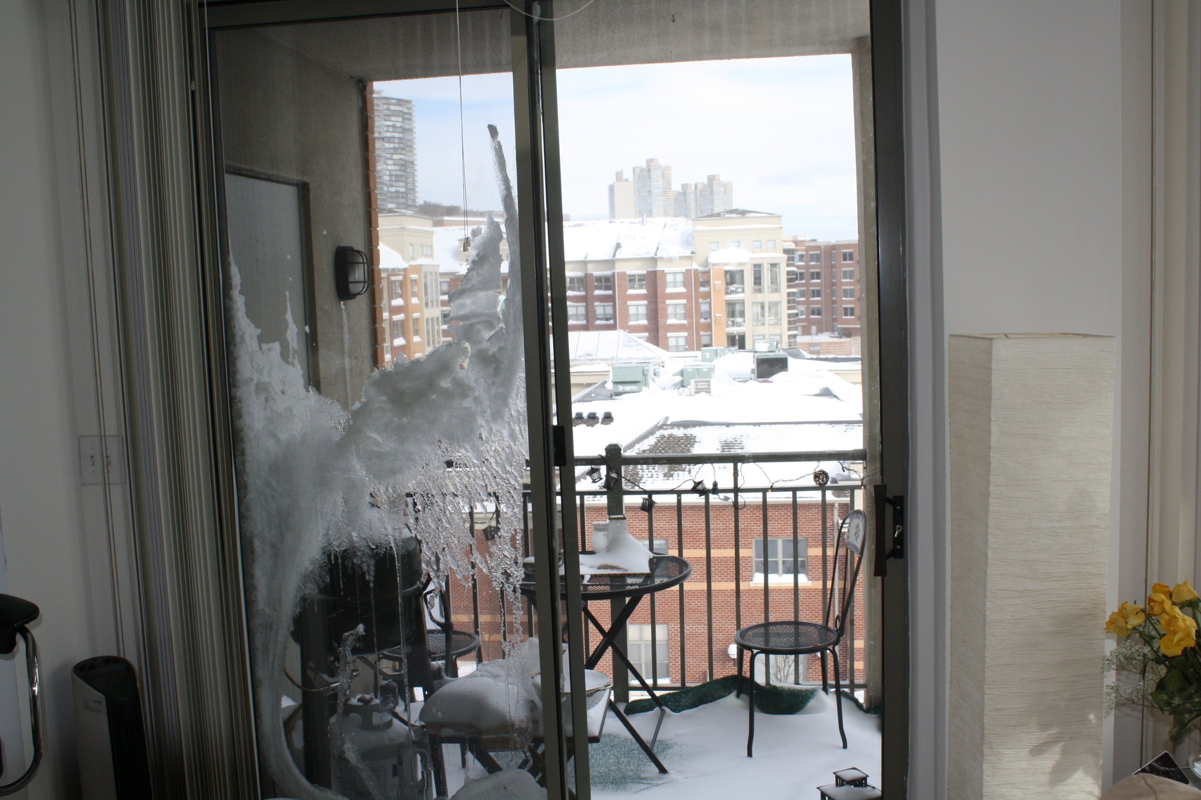 Snow and ice against an apartment window overlooking New York
