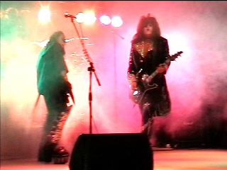 Benny Doro performing as Paul Stanley under red stage lights, photograph 1 of 22