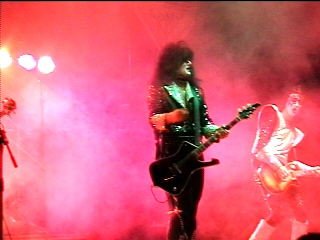 Benny Doro holding his guitar onstage, photograph 5 of 22