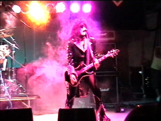 Benny Doro singing and playing guitar onstage, photograph 20 of 22